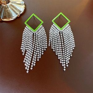 Detailed view of hollow diamond-set rhombus earrings with long silver fringe tassels