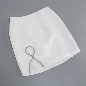 Detail of white satin mini skirt with shimmering silver rhinestone chain embellishments