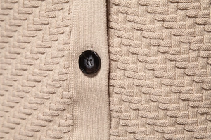 Macro shot of beige waffle knit fabric texture and premium black four-hole button