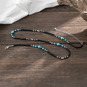 Bohemian seed bead necklace for men featuring turquoise stones on a dark wood background