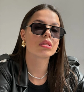 Close-up of stylish double-bridge square sunglasses on a female model wearing a leather jacket