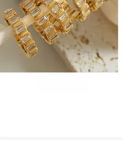 Macro di collane con angelo placcate in oro con zirconi a baguette su supporti bianchi