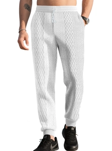 Detail of men's white waffle knit joggers featuring elastic waist and ribbed cuffs