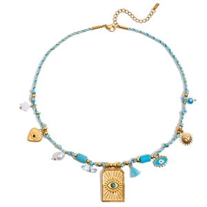 Detail of blue braided necklace with golden evil eye, heart, and star pendants