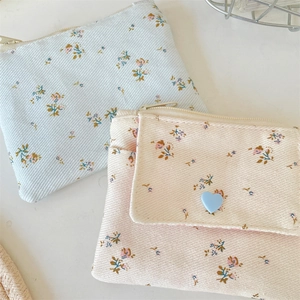 Gros plan de portefeuilles en velours côtelé fleuri bleu et rose avec fermeture éclair