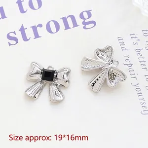 Detailed macro view showing silver bow pendant dimensions 19x16mm with black gemstone