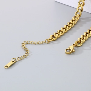 Detailed view of a gold Cuban link chain anklet with lobster clasp and extension link