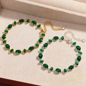 Detail of gold and silver bracelets with green zircon gemstones in a jewelry box