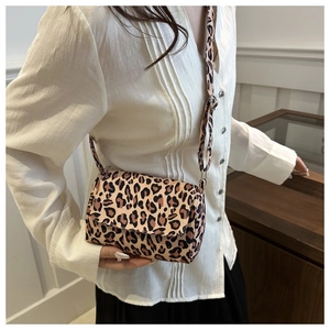 Close-up of leopard print crossbody bag with adjustable strap on a fashion model