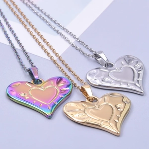 Close-up of heart-shaped pendants in gold, silver, and rainbow finishes with relief detail