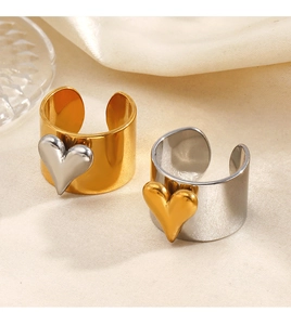 Gros plan de bagues coeur bicolores sur satin, détails contrastés or et argent