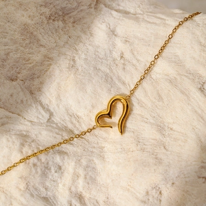 Collier minimaliste à pendentif cœur doré avec design ajouré sur socle en pierre naturelle