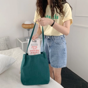 Detail of dark green cotton linen tote bag showing interior capacity with a book inside