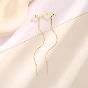 Detail of elegant gold star tassel drop earrings with five-pointed star zircon accents