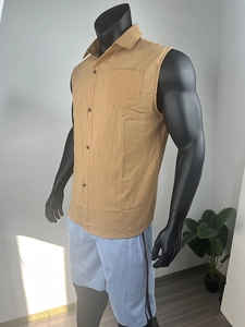 Detail of mustard yellow sleeveless linen shirt with wooden buttons and waffle texture