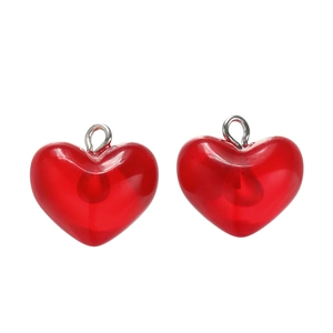 Macro shot of two translucent dark red heart pendants with polished silver metal rings