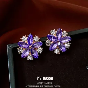 Elegant floral cluster earrings with purple crystals and white rhinestones on velvet