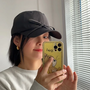 Close-up of a sweet black satin bow detail on a breathable cotton baseball cap for women