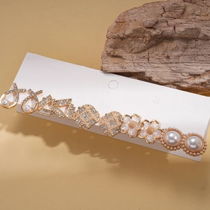 Elegant set of ten gold earrings with faux pearls and crystals on a white card display