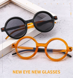 Detail of round punk sunglasses in black and amber frames with metallic studs