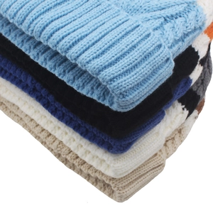 Macro shot of assorted colorful chunky cable knit beanies with warm fleece lining