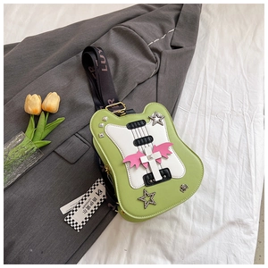Detail of green guitar-shaped crossbody bag with pink wings and wide logo shoulder strap