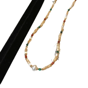 Colorful baroque pearl necklace with red and green beads on a clean white background