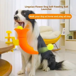 Detail of orange pet ball launcher fixed to a table edge with a yellow tennis ball