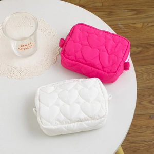Close-up of candy-colored heart quilted mini makeup pouches in pink and white