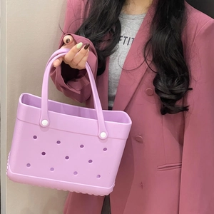 Mid-sized lavender EVA beach bag with holes held by model in pastel blazer
