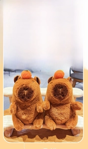 Detail of plush capybara keychains with orange head deco and soft fuzzy texture