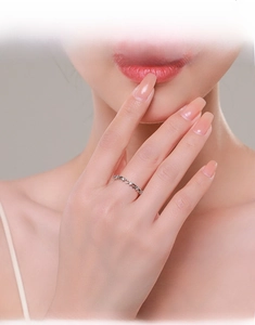 Model wearing a delicate s925 silver hollow heart ring set with white cubic zirconia