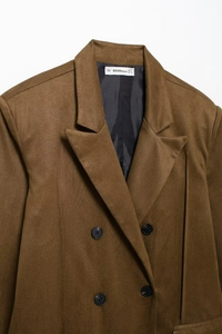 Detail of notch lapel and black double-breasted buttons on brown retro blazer