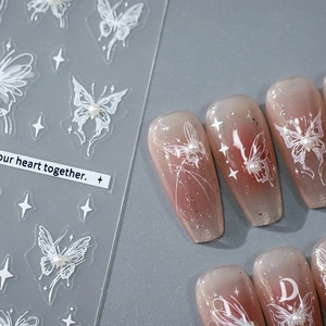 5D butterfly nail stickers with white hollow designs and small pearl accents