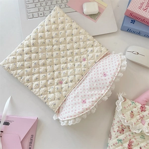 Close-up of quilted floral 11-inch laptop sleeve with lace trim and snap closure