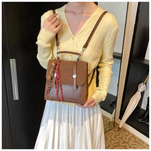 Detalle de bolso vintage de cuero con borla y correa ajustable puesto en una modelo