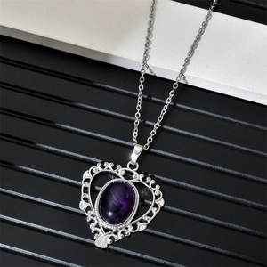 Détail du collier cœur filigrané serti d'une pierre précieuse ovale violette