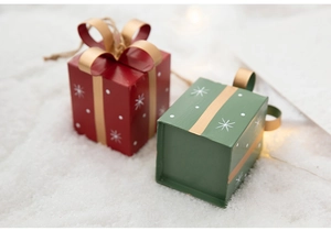 Close-up of red and green metal Christmas gift box ornaments with snowflakes and bows