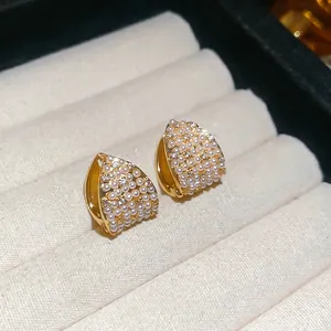 French vintage gold triangle earrings with pearls and cubic zirconia on beige velvet