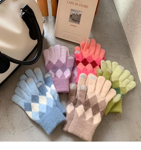 Close-up of colorful knit gloves with diamond patterns and touchscreen fingertips