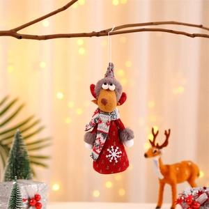 Detailed plush reindeer ornament with red knit sweater on a rustic branch backdrop
