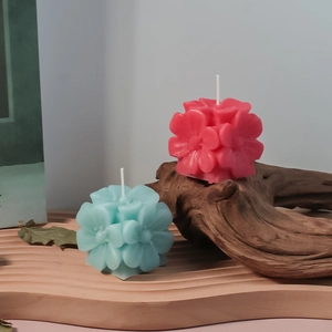 Detalle de velas perfumadas florales rosa y azul en una bandeja de madera rústica