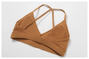 Macro view of caramel V-neck sports bra with multi-strap criss-cross back and elastic band