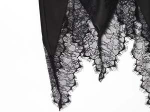Detailed close-up of the black satin fabric and delicate floral eyelash lace stitching
