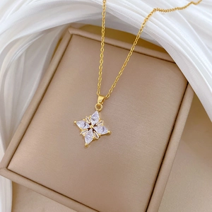Detail of clover diamond necklace with four triangle zircons on gold chain over silk