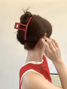 Close-up of a large glossy red geometric hair claw clip styled on a model's hair