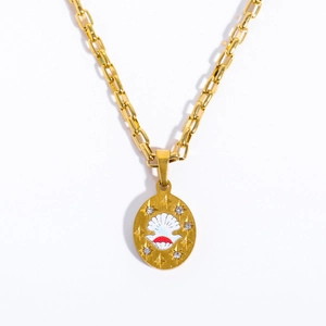 Detail of gold oval pendant featuring red enamel shell design with crystal accents