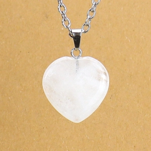 Detailed macro view of white crystal heart pendant necklace with silver chain link