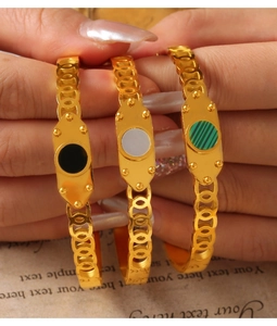 Detail of gold-plated titanium bracelets with colorful round inlays and chain link design