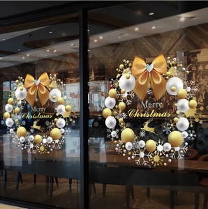 Detail of Christmas window sticker featuring gold reindeer wreaths and Merry Christmas text